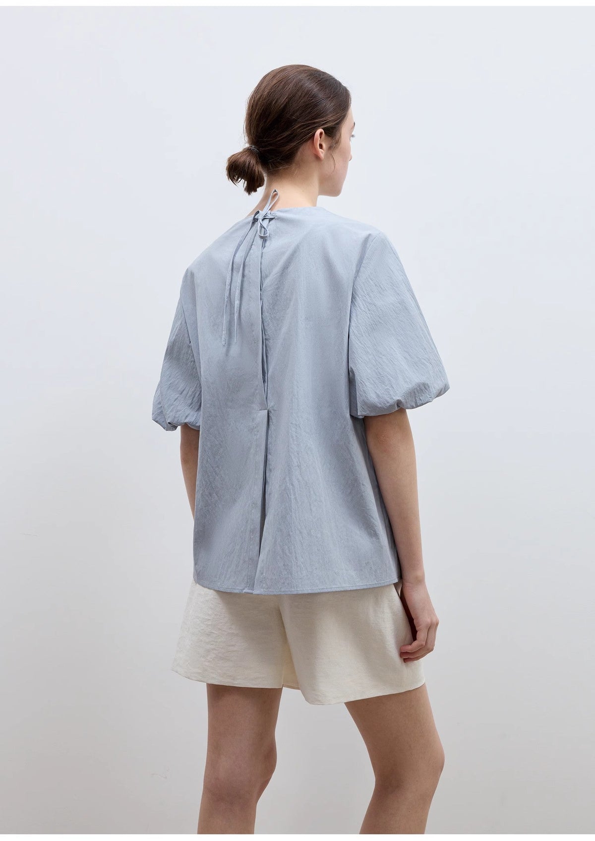 Camisa de mujer "Iceland Diary" con diseño plisado en el escote, cuello redondo, lazo y mangas abullonadas de manga corta