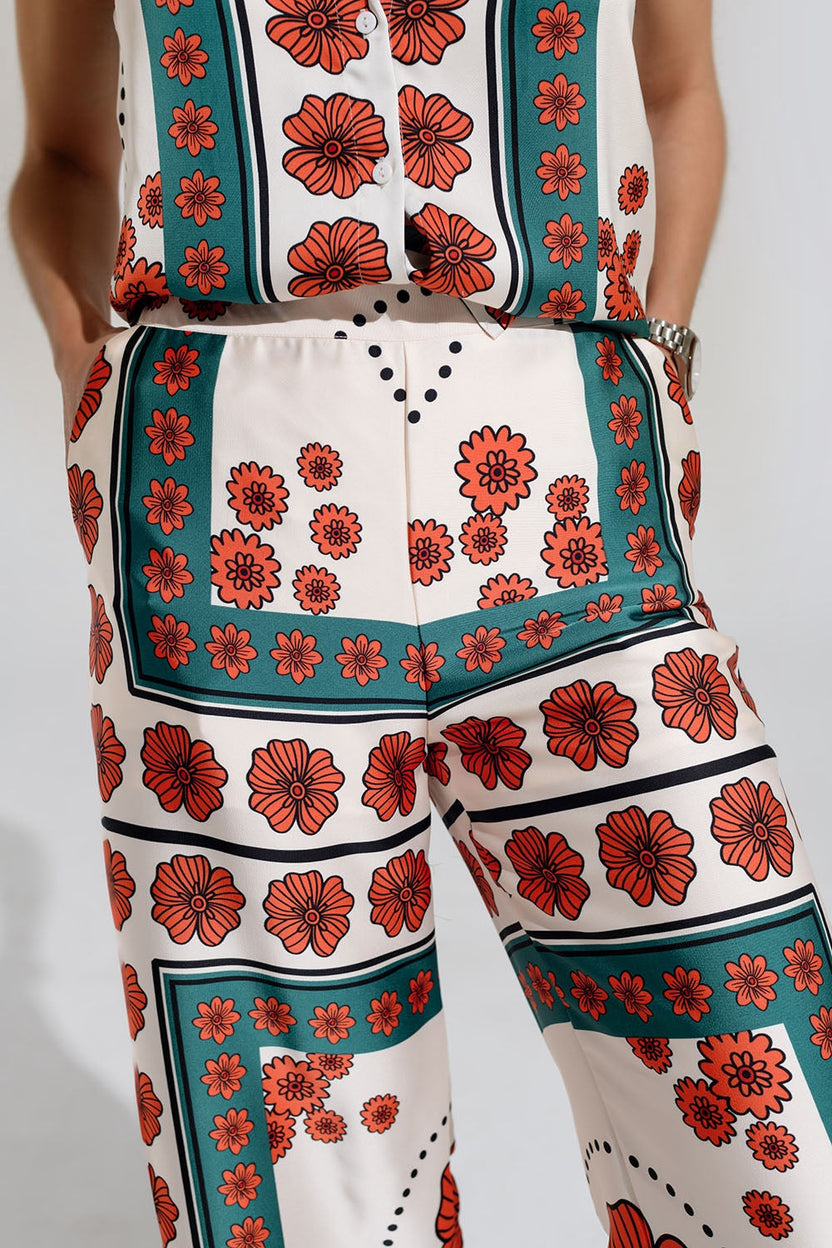 Pantalones acampanados de satén color crema con diseño floral